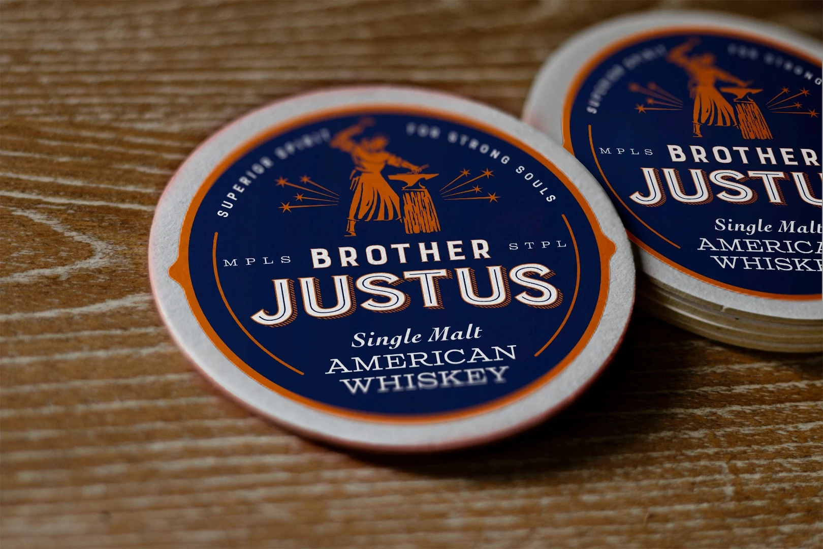 Brother Justus branded coasters with monk-blacksmith medallion on a wooden table
