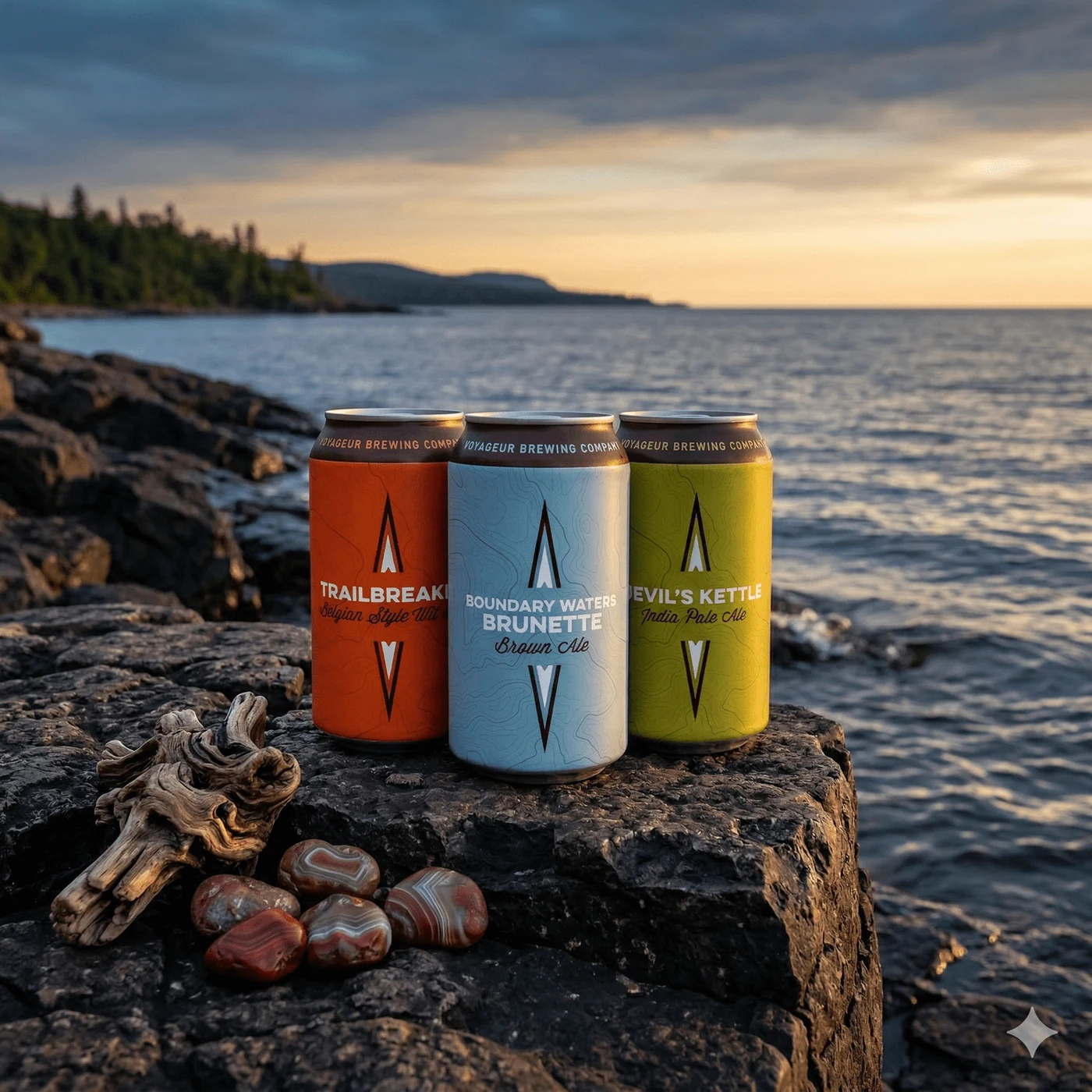 Voyageur Brewing beer cans on rocks at a lake at sunset